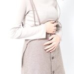 お腹をおさえる便秘の女性